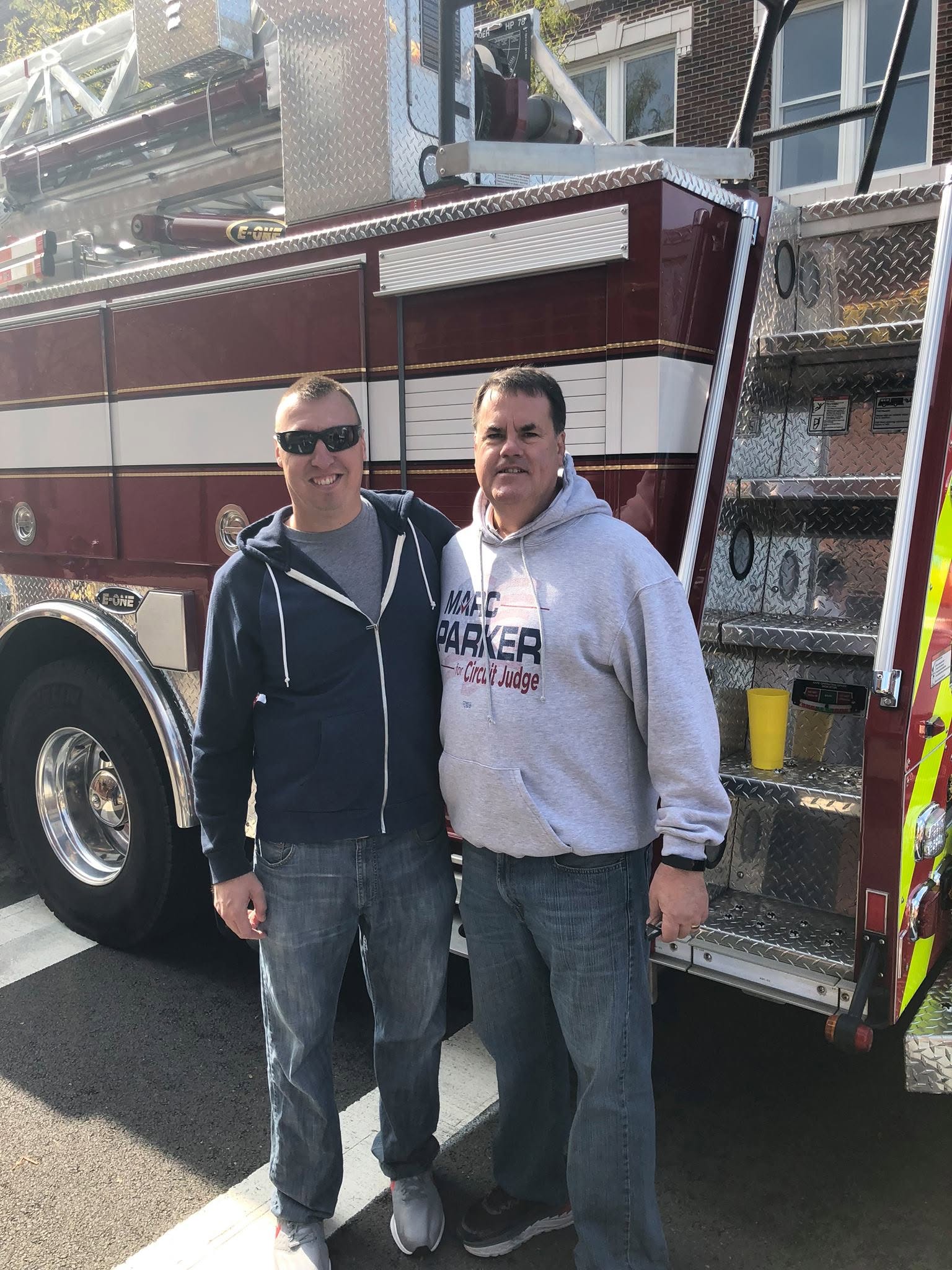 Marc Parker with a firefighter in front of a fire truck